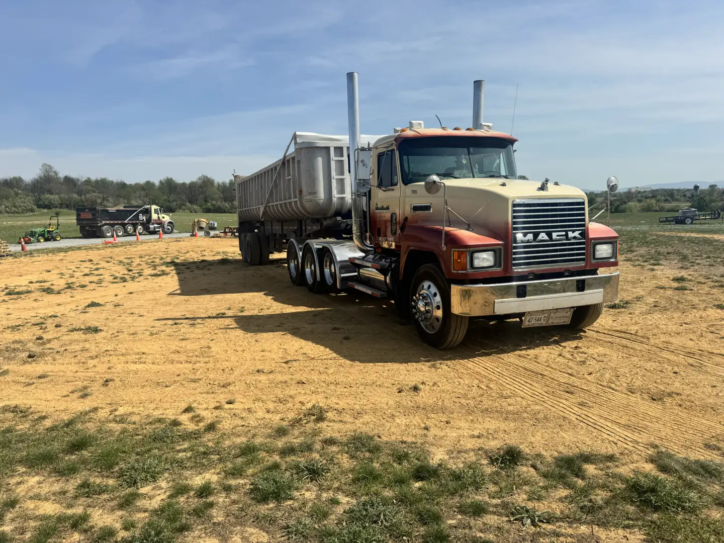 A Pine Knoll Construction dump trailer and truck delivering screened clay and screened topsoil to Victory Church in Winchester VA.