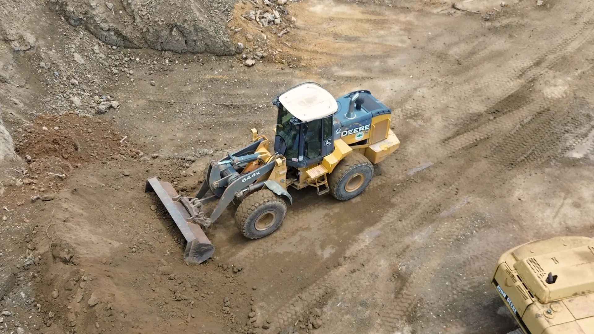 Aerial photo of a rubber tire loader scooping up dirt for screened topsoil