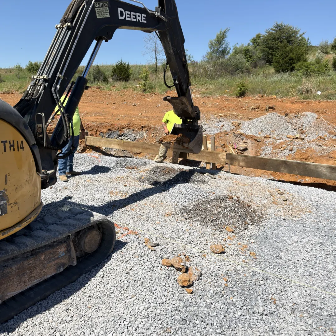 Mini excavator digging a concrete pad for a dumpter pad at the taco bell site.